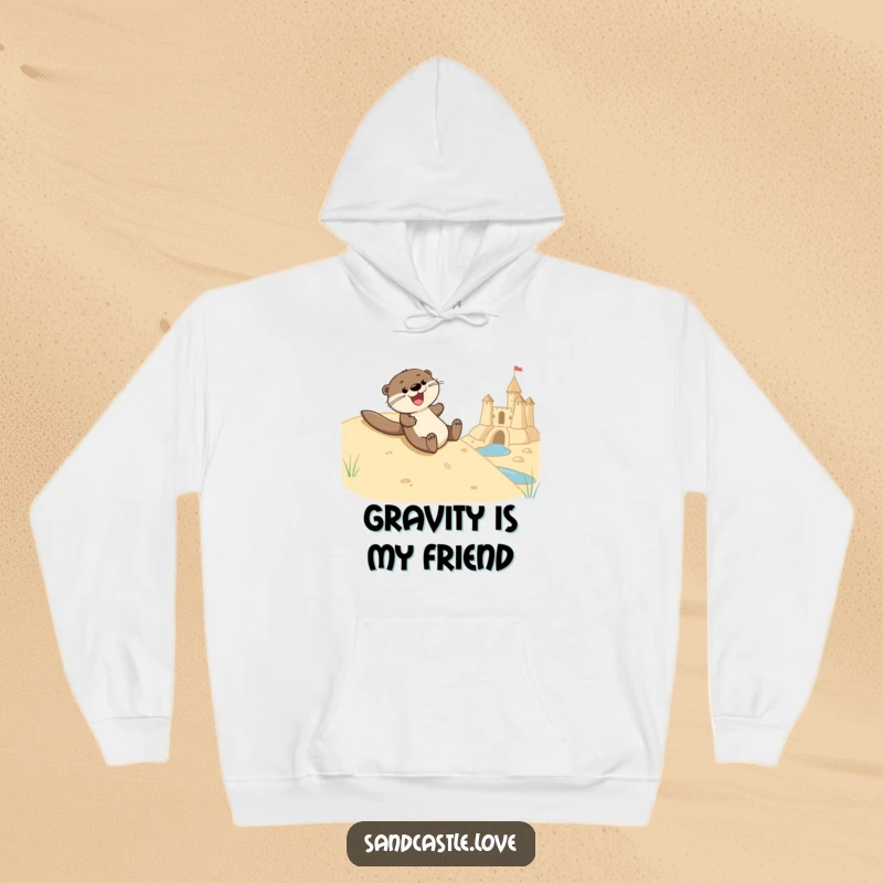 Funny hoodie depicting a joyful otter character smoothly sliding down a sandy embankment towards a sandcastle's water feature, radiating happiness.