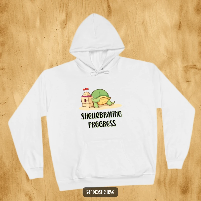 Hoodie showcasing a cute turtle character diligently pushing a small, decorated sandcastle brick, perfect for beach lovers and slow-paced fun.